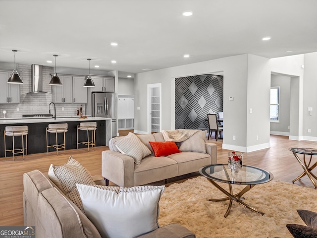 living room featuring recessed lighting, light wood-style flooring, and baseboards