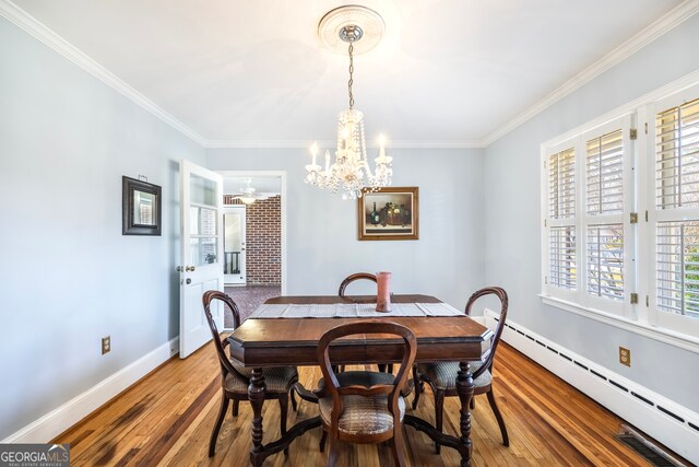 dining space featuring baseboards, a chandelier, a baseboard radiator, ornamental molding, and wood-type flooring