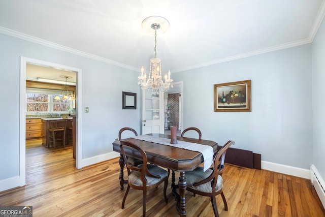 dining room featuring an inviting chandelier, light wood-type flooring, and ornamental molding