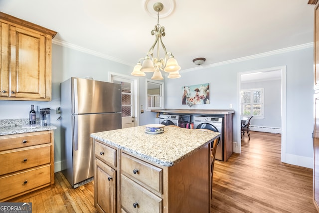 kitchen featuring washer / dryer, crown molding, and freestanding refrigerator