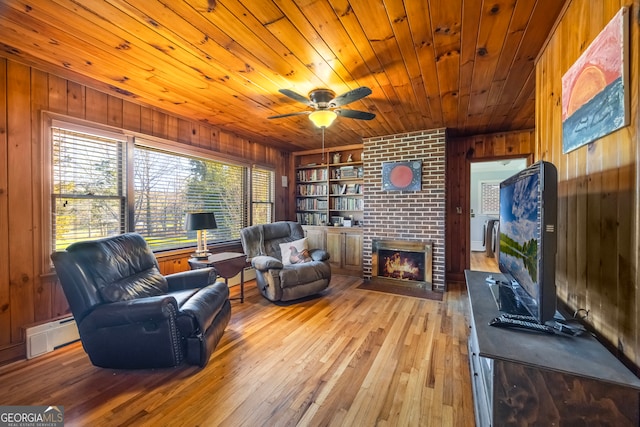 living area with wooden ceiling, hardwood / wood-style flooring, a fireplace, and wood walls