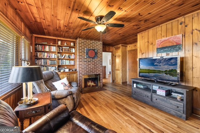 living room with wooden ceiling, wood finished floors, a fireplace, and wood walls