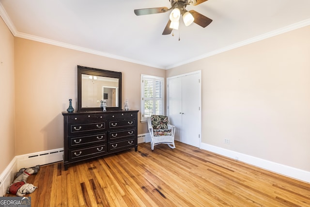 living area featuring baseboards, wood finished floors, and ornamental molding