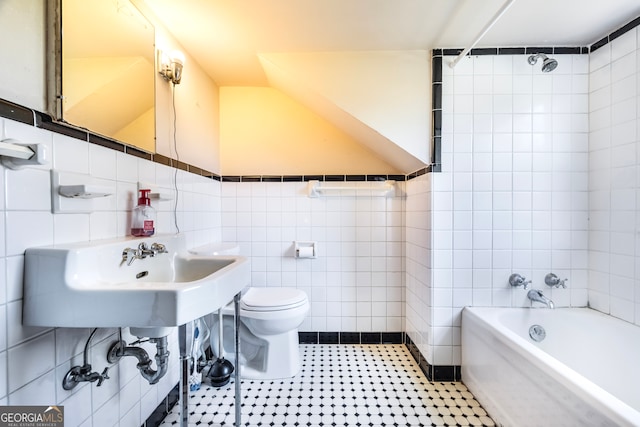 bathroom with a bathing tub, a sink, tile walls, toilet, and tile patterned floors