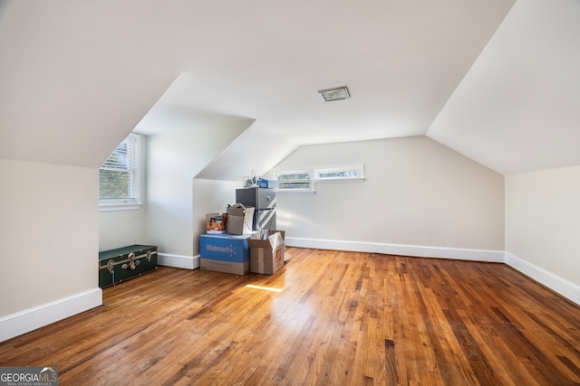 bonus room featuring vaulted ceiling, baseboards, and wood-type flooring