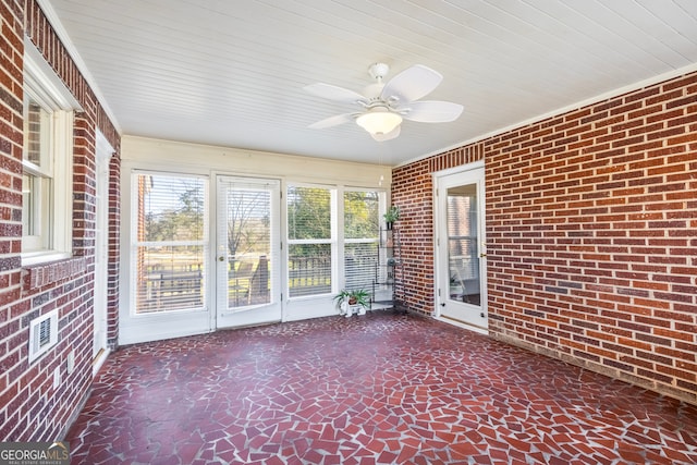 unfurnished sunroom featuring a ceiling fan and visible vents