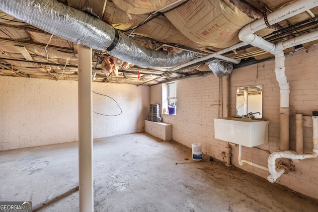 below grade area featuring brick wall and a sink