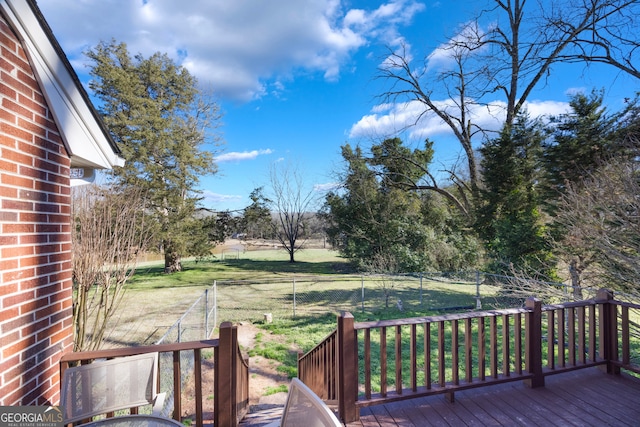 wooden terrace with a lawn and a fenced backyard