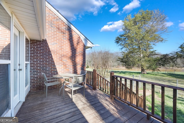 wooden terrace featuring a yard