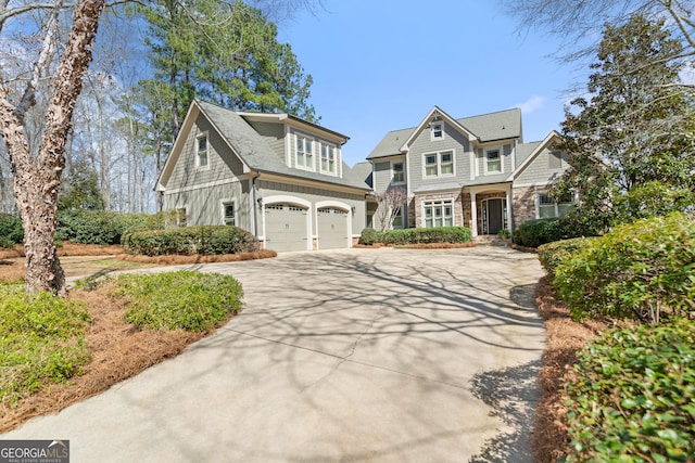 shingle-style home featuring stone siding, concrete driveway, and an attached garage