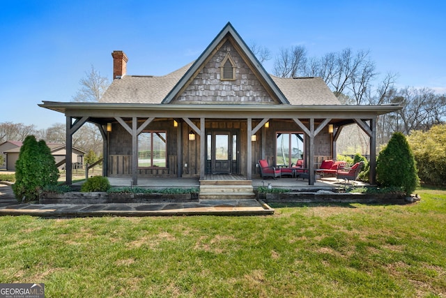 exterior space featuring a lawn, covered porch, roof with shingles, and a chimney