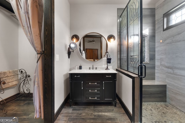 full bath with baseboards, vanity, a shower stall, and wood tiled floor