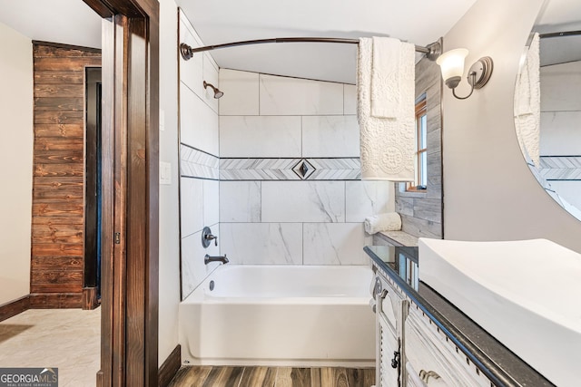 bathroom featuring vanity, bathing tub / shower combination, and wood finished floors