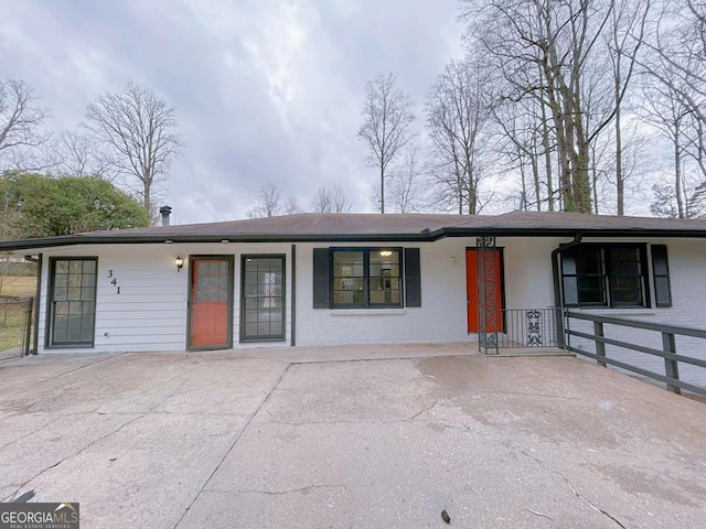 single story home featuring brick siding and a porch