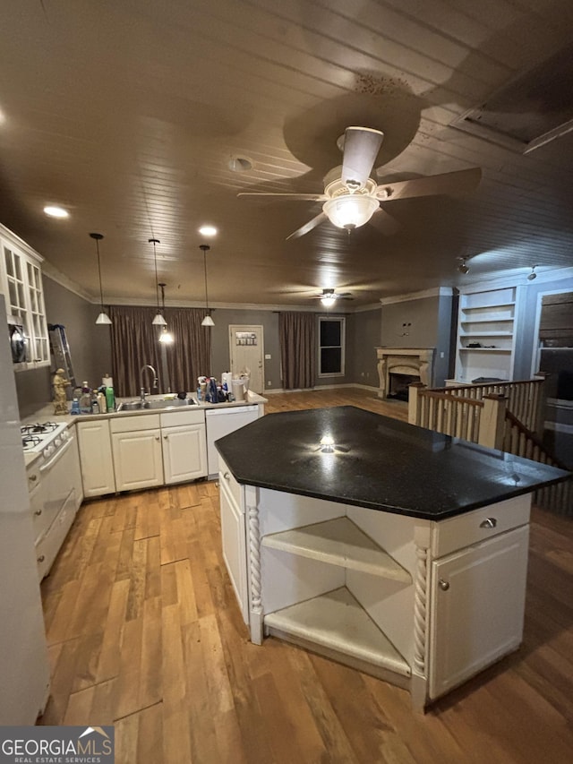 kitchen featuring a sink, open shelves, white cabinetry, a peninsula, and light wood finished floors