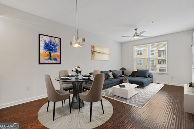 dining space with a ceiling fan, wood finished floors, and baseboards