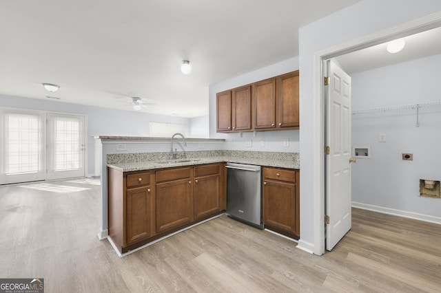 kitchen featuring dishwasher, a peninsula, brown cabinets, and a sink