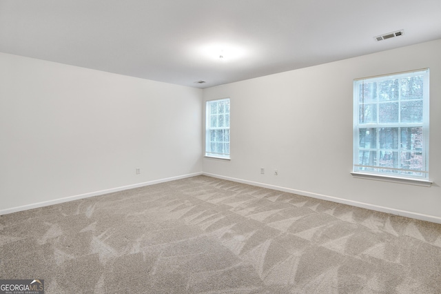 carpeted spare room with baseboards and visible vents