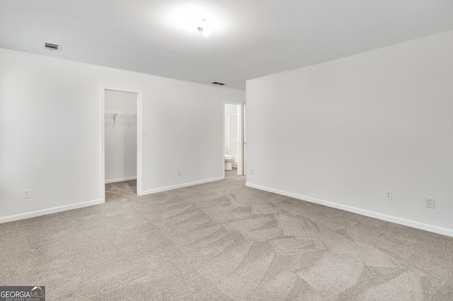 unfurnished room featuring visible vents, carpet floors, and baseboards