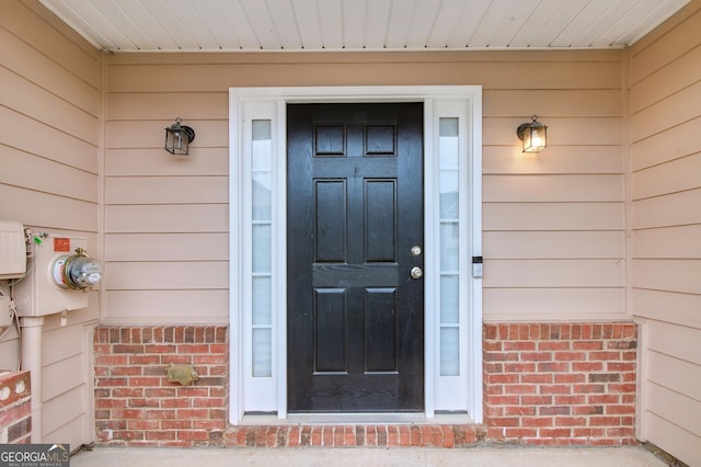 entrance to property featuring brick siding