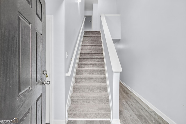 stairs with baseboards and wood finished floors