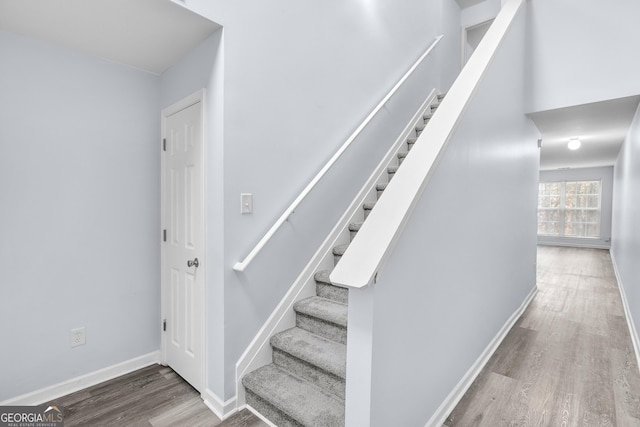 stairway with baseboards and wood finished floors