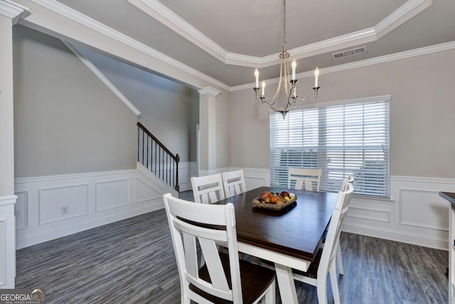 dining room with visible vents, dark wood finished floors, an inviting chandelier, stairs, and ornate columns