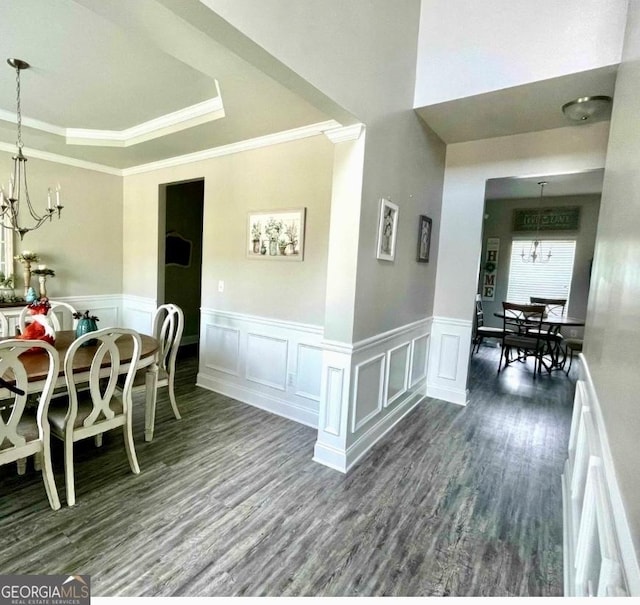 dining room featuring an inviting chandelier, crown molding, wood finished floors, and a tray ceiling