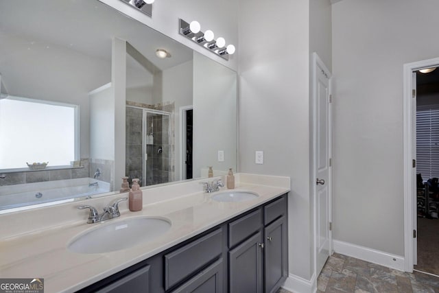 bathroom featuring a sink, baseboards, a stall shower, and double vanity