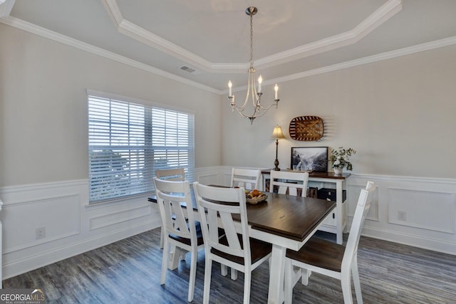 dining space featuring wood finished floors, a wainscoted wall, visible vents, a tray ceiling, and a notable chandelier