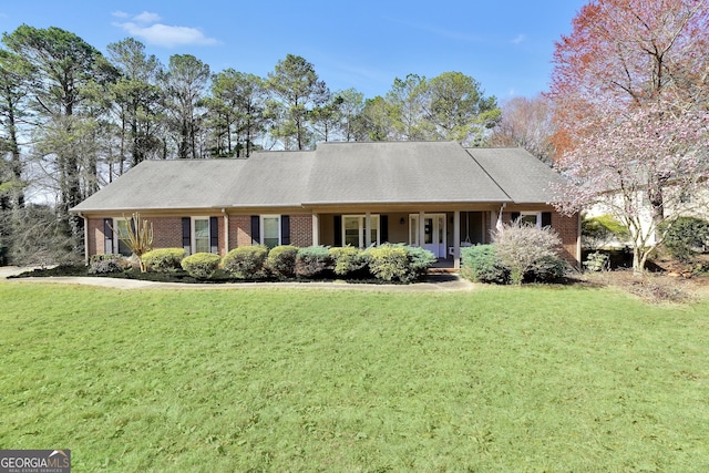 single story home with brick siding, a porch, and a front lawn