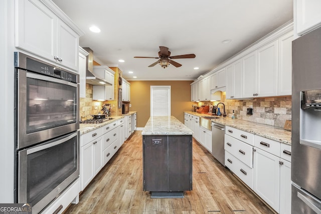 kitchen with light wood finished floors, recessed lighting, white cabinets, appliances with stainless steel finishes, and backsplash