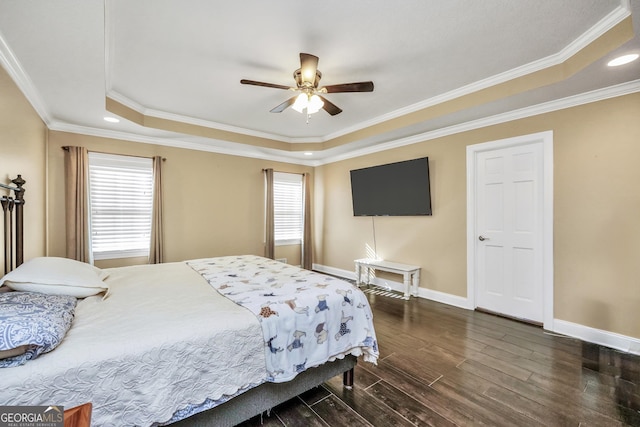 bedroom with a ceiling fan, dark wood-style floors, baseboards, a tray ceiling, and ornamental molding