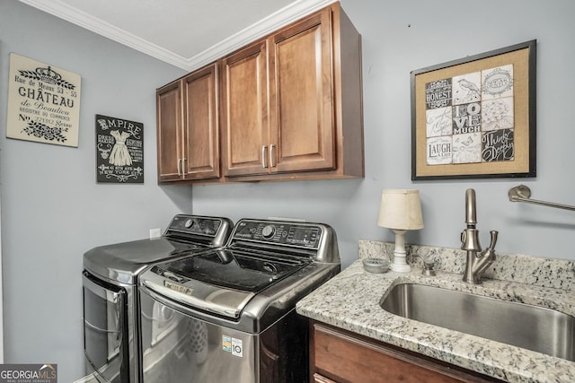 washroom with cabinet space, ornamental molding, separate washer and dryer, and a sink