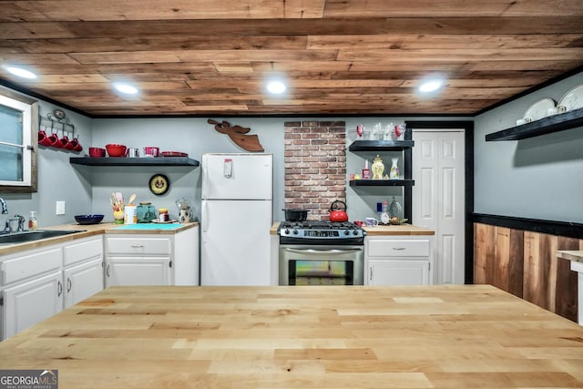 kitchen featuring open shelves, stainless steel range with gas cooktop, wood ceiling, and freestanding refrigerator