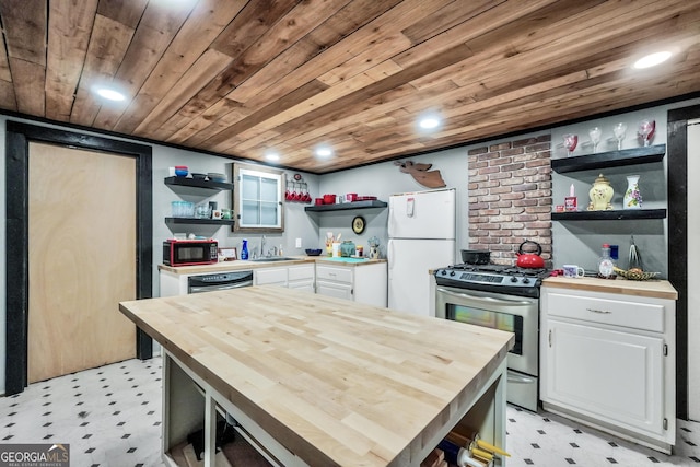 kitchen with butcher block countertops, open shelves, freestanding refrigerator, white cabinets, and stainless steel gas range