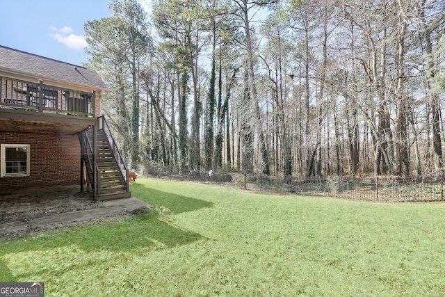 view of yard featuring stairway, a deck, and fence