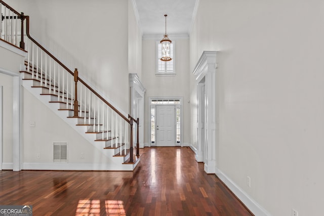 foyer entrance featuring visible vents, wood finished floors, decorative columns, baseboards, and stairs