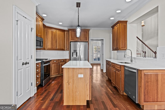 kitchen with a sink, a kitchen island, appliances with stainless steel finishes, crown molding, and light countertops