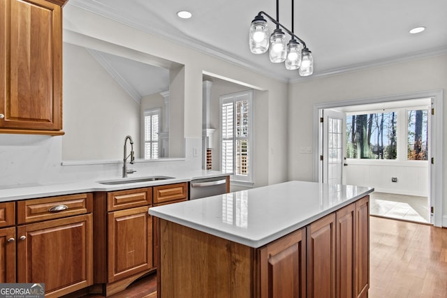 kitchen with stainless steel dishwasher, light countertops, ornamental molding, and a sink