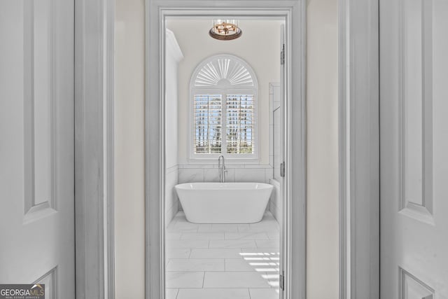 full bath featuring tile walls and a freestanding bath