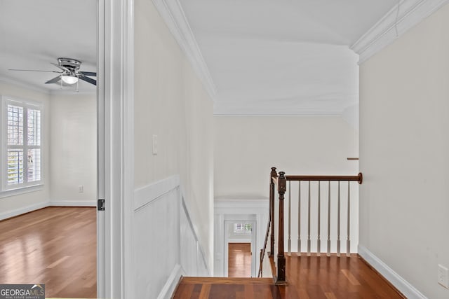 stairs featuring wood finished floors, a ceiling fan, baseboards, and ornamental molding