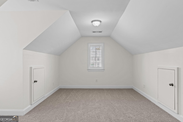additional living space featuring lofted ceiling, carpet flooring, baseboards, and visible vents