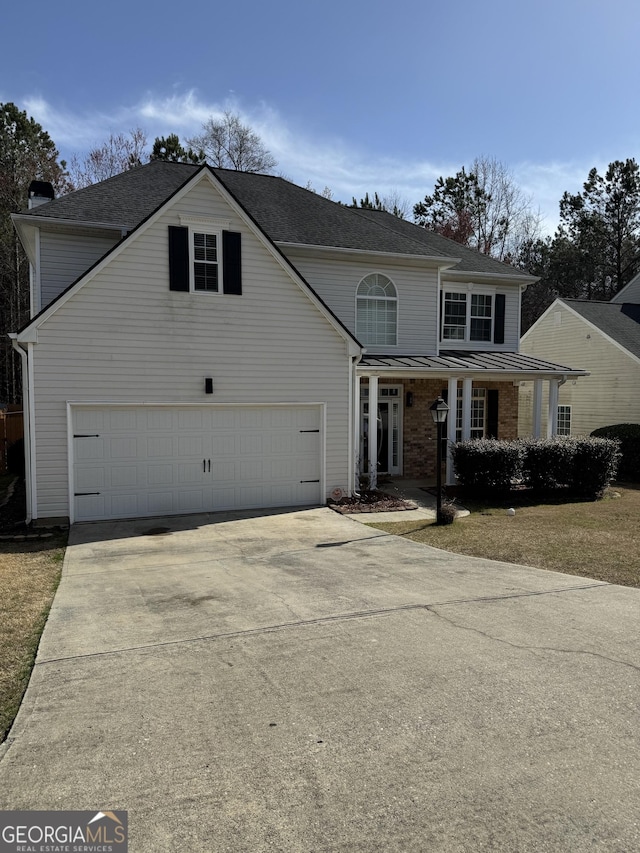 traditional-style house with concrete driveway, a chimney, metal roof, a garage, and a standing seam roof