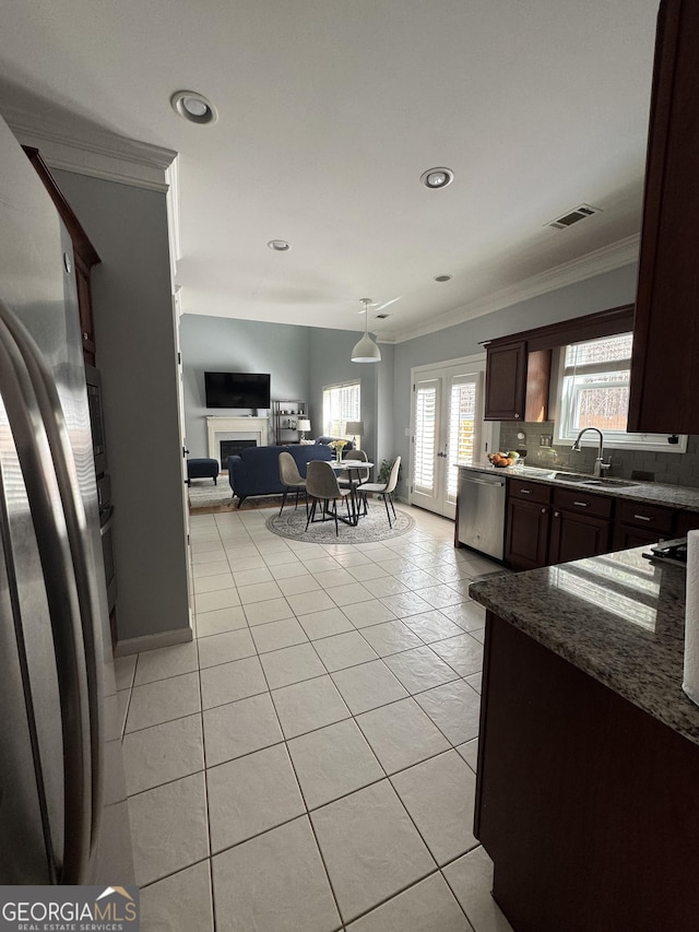 kitchen featuring visible vents, ornamental molding, a sink, backsplash, and stainless steel appliances