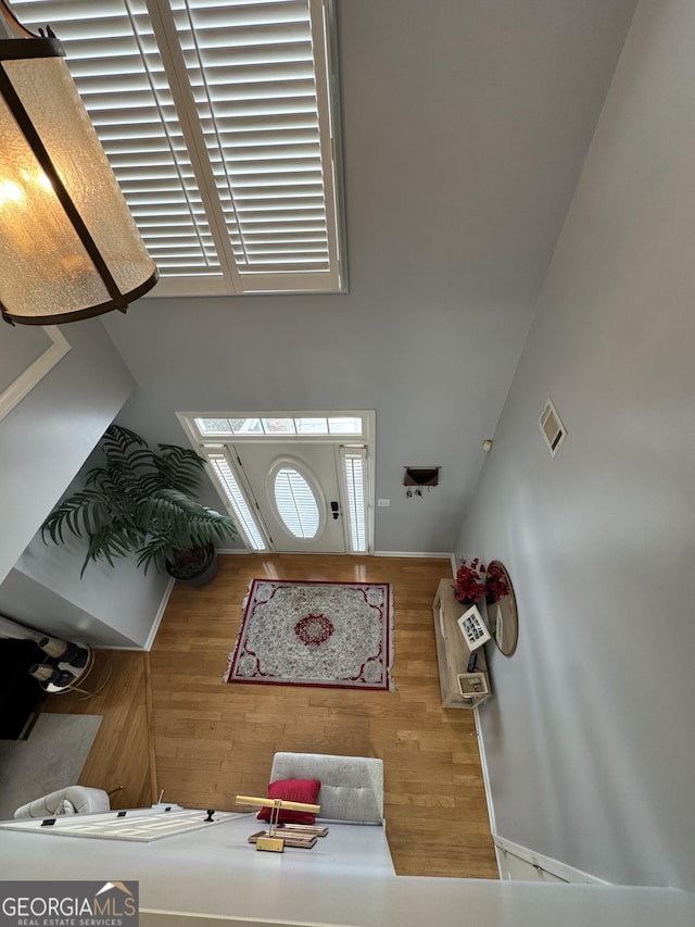 foyer entrance with visible vents and wood finished floors