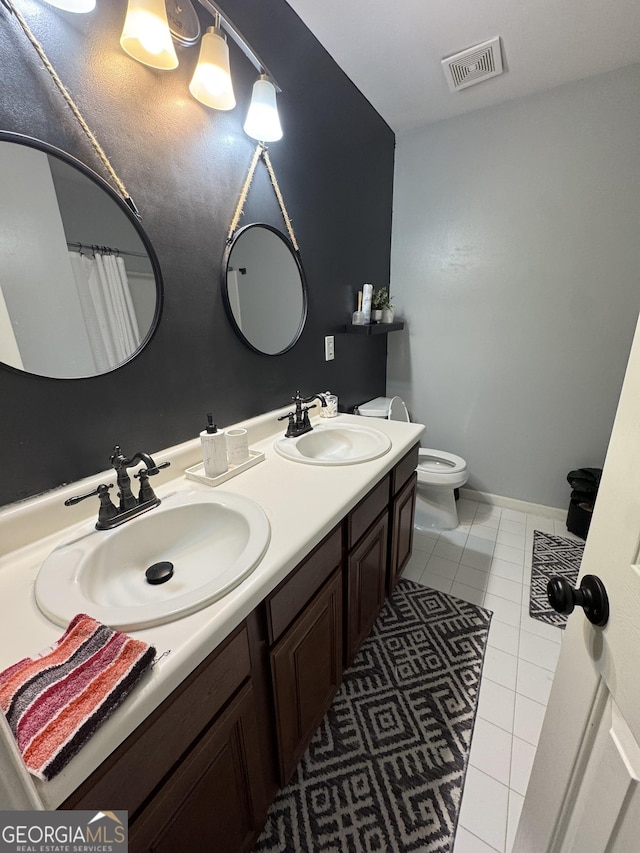 bathroom with double vanity, visible vents, tile patterned floors, and a sink