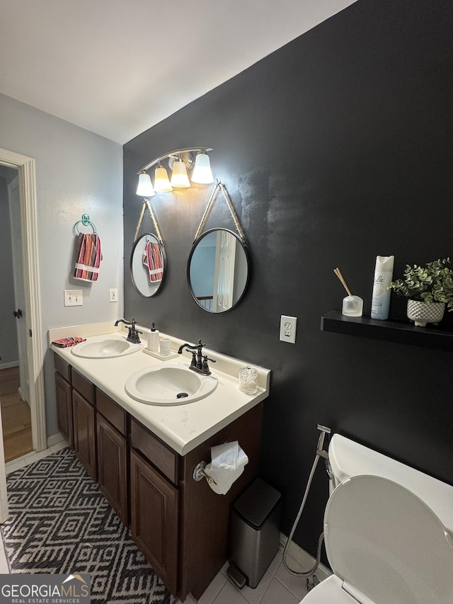 bathroom featuring double vanity, toilet, tile patterned floors, and a sink