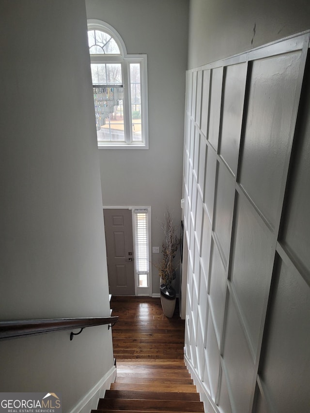 stairway with wood finished floors and baseboards