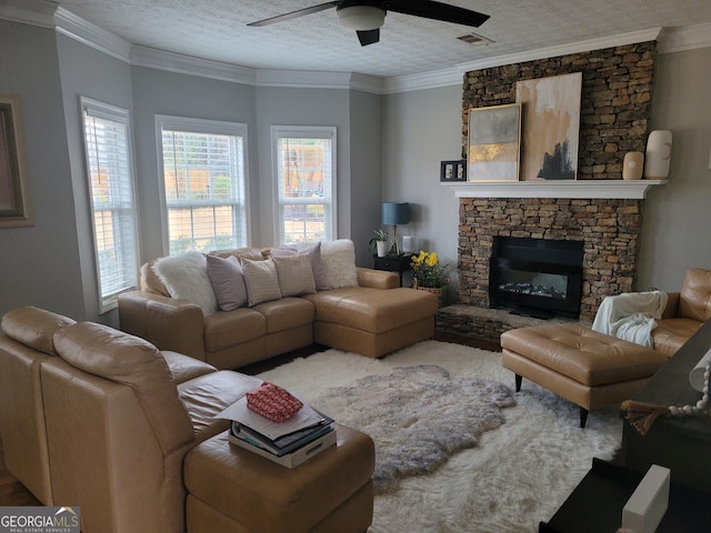 living area with ceiling fan, ornamental molding, visible vents, and a textured ceiling